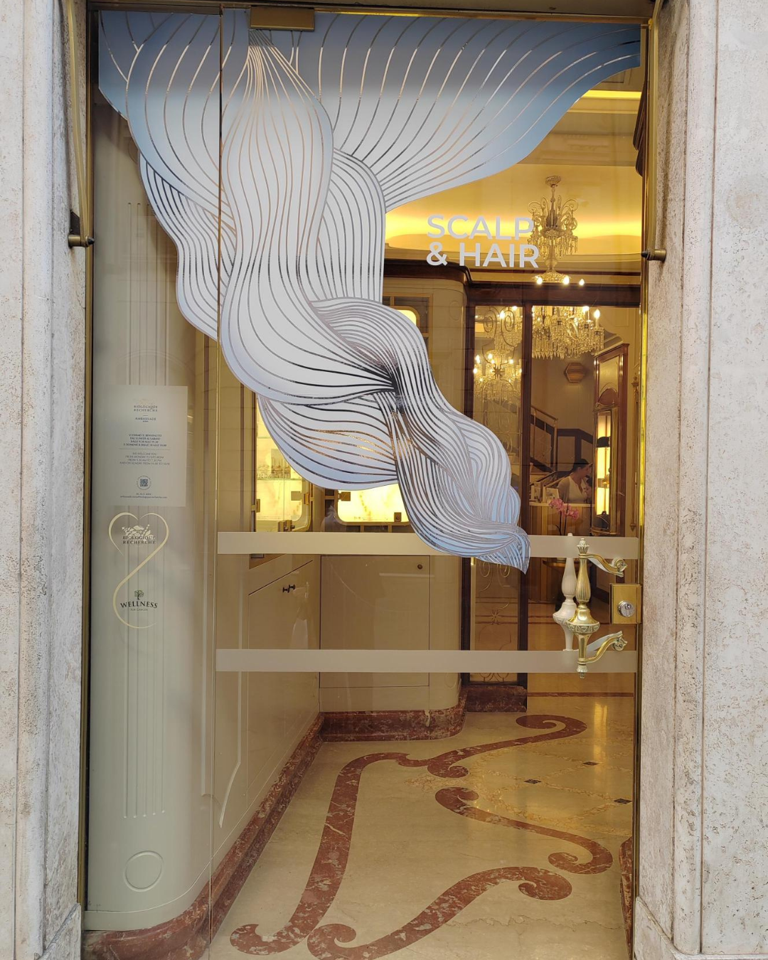 Reflets argentés et jeux de lumière dans une scénographie de vitrine pour une marque de cosmétiques.