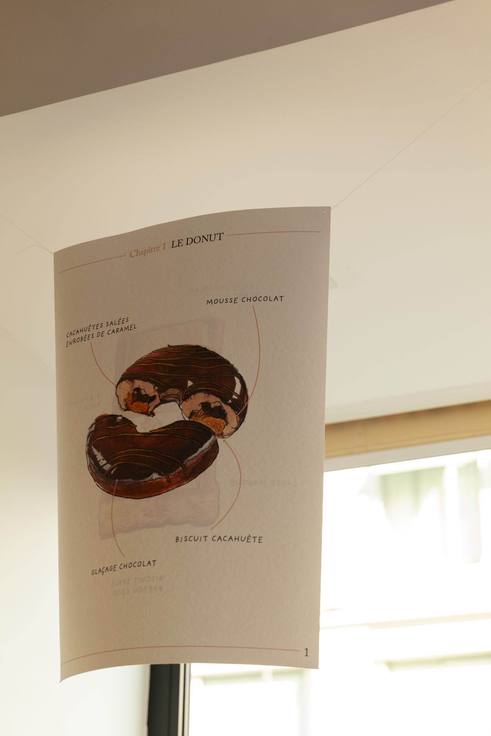 Détail d’une illustration sur-mesure réalisée à l’aquarelle pour la vitrine anniversaire. Plutôt qu’un pictogramme, chaque pâtisserie emblématique est peinte pour retrouver la sensibilité d’un livre d’images et l’univers de souvenirs gourmands de la Maison.
