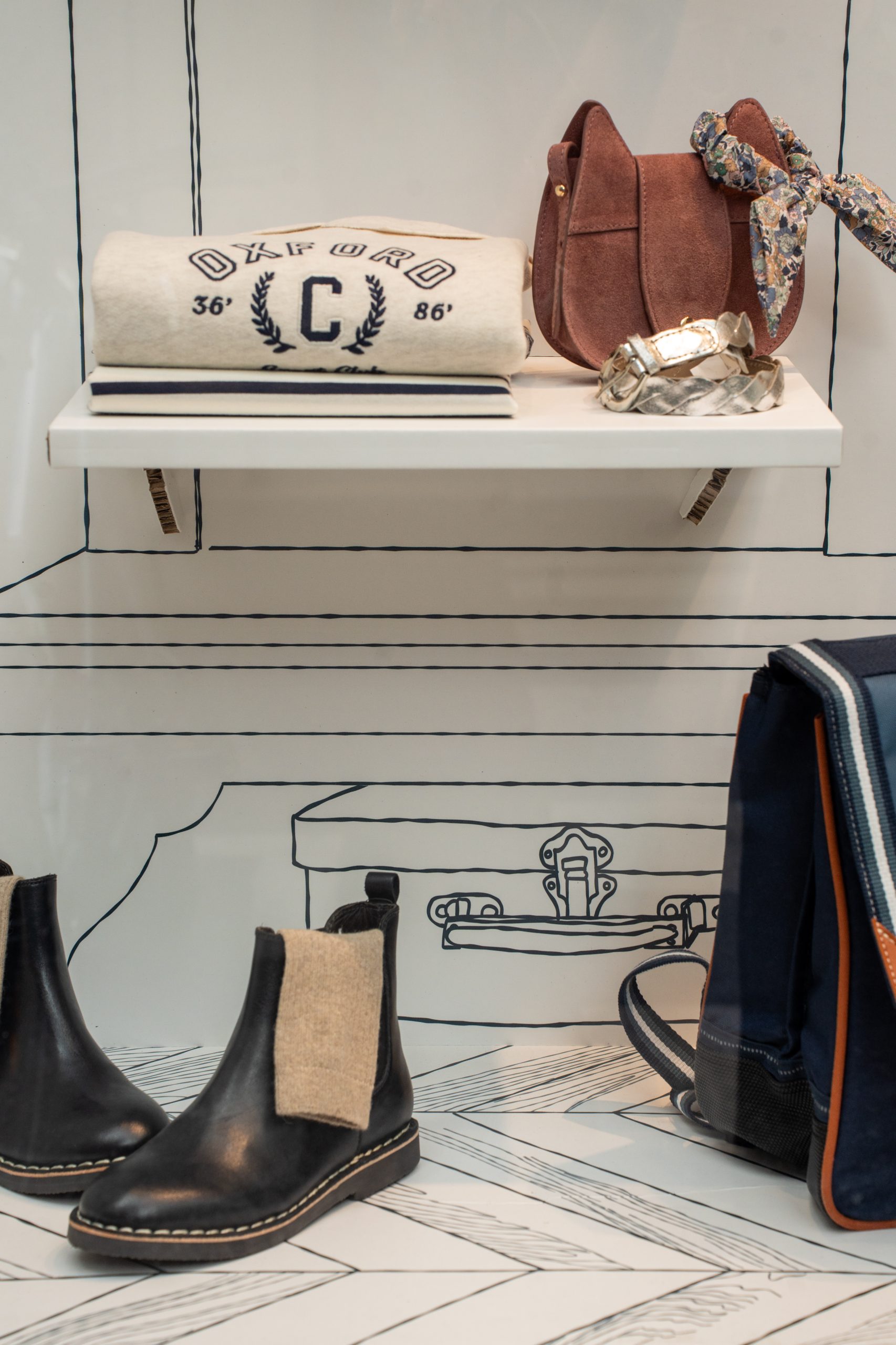 Vitrine de rentrée Cyrillus sans mannequin : une armoire illustrée sur-mesure pour valoriser la mode enfant. Scénographie retail par Twist Design.