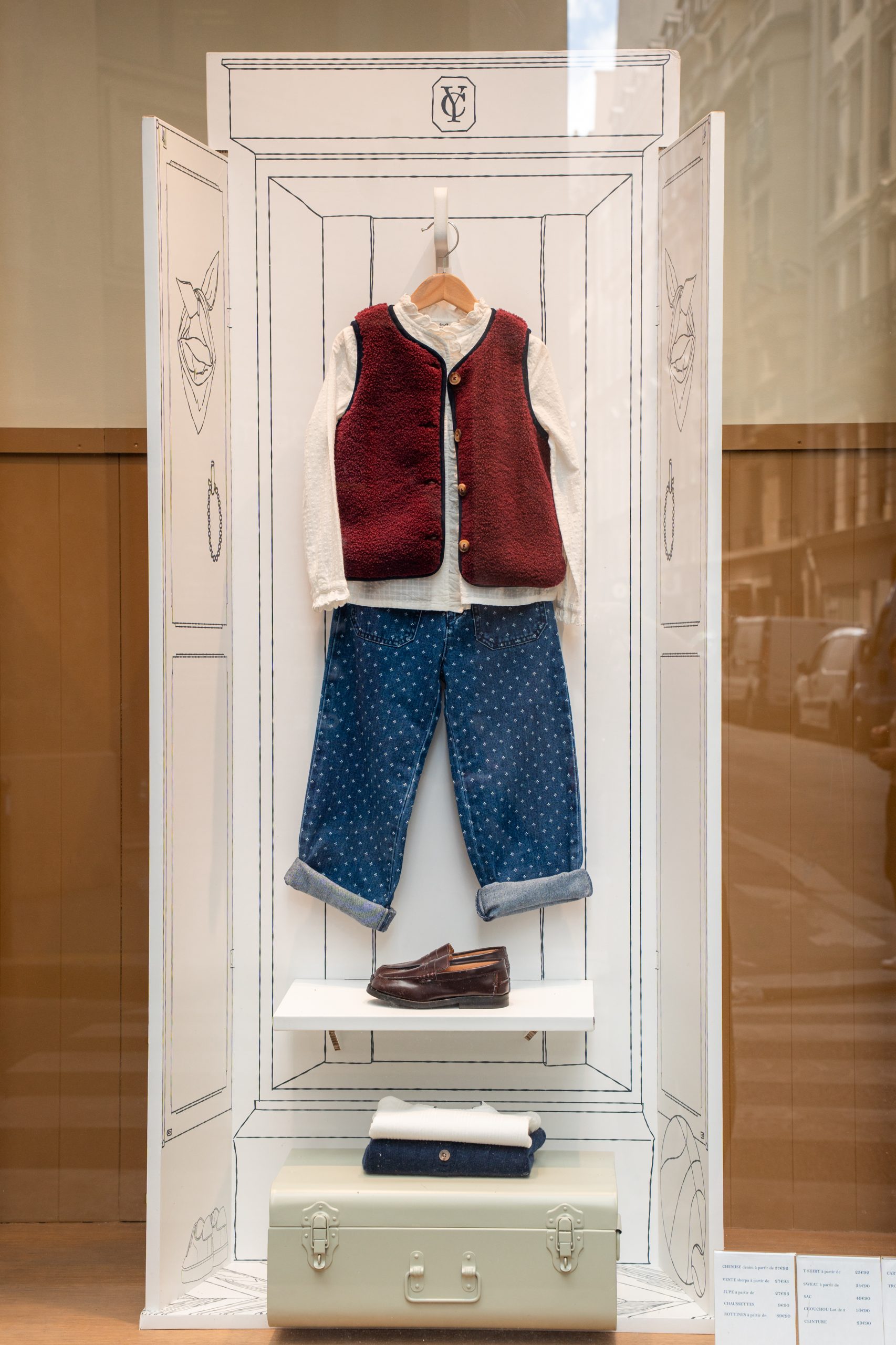 Vitrine mode enfant Cyrillus : tenue de rentrée présentée dans une armoire de papier illustrée